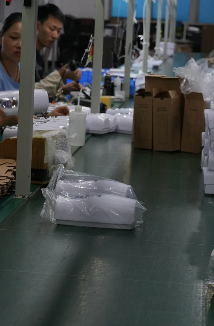 Factory team completing product packing at a workstation